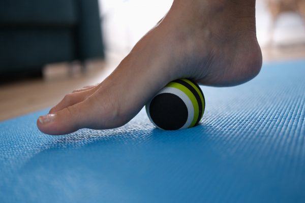 A tennis ball rolling stretch can help alleviate plantar fasciitis pain.